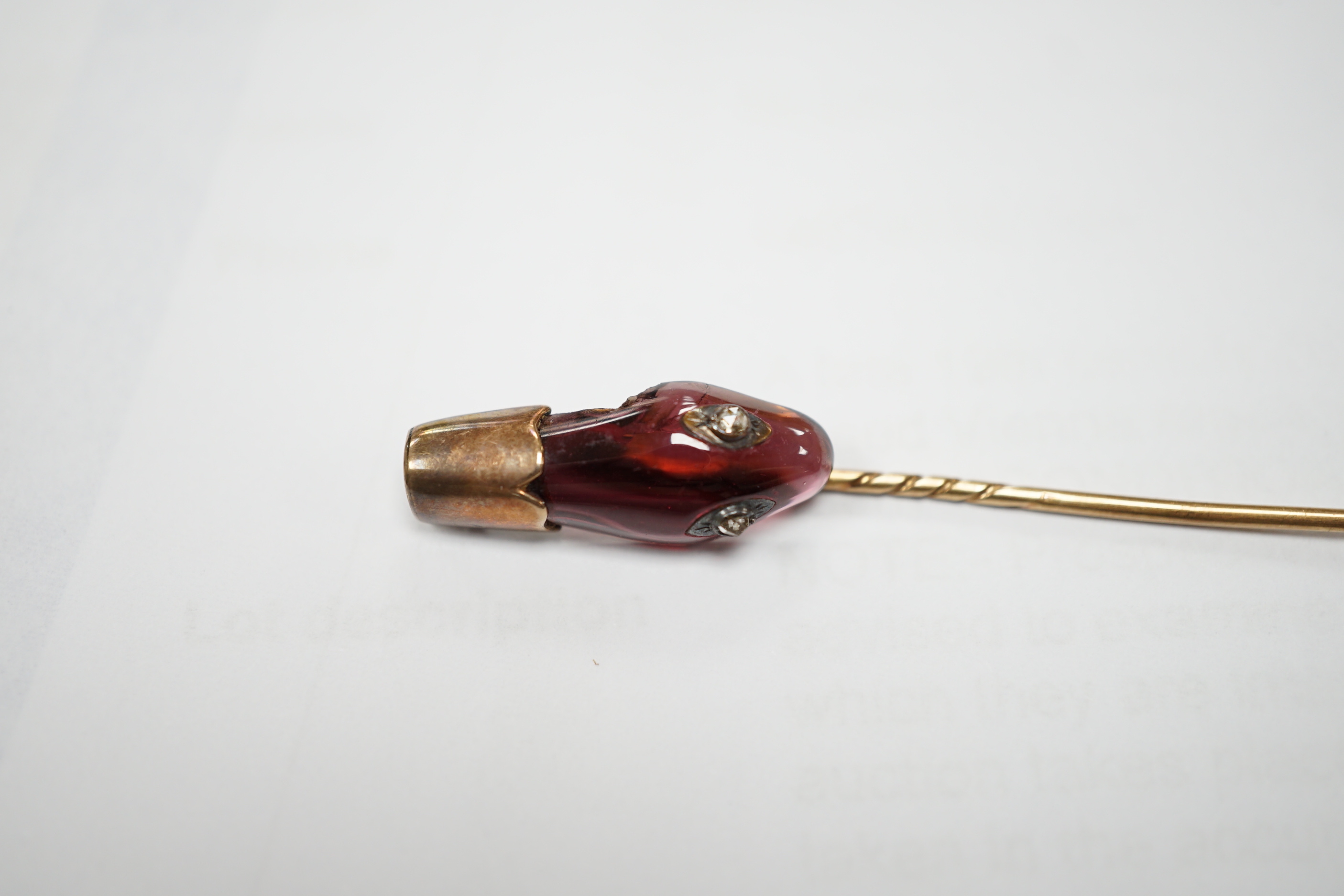 A late Victorian yellow metal, garnet and diamond set serpent head stick pin, 65mm, gross weight 2.9 grams (chip).
